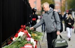 Un homme dépose des fleurs à l'entrée du campus de l'université de Perm (Russie), le 21 septembre 2021, au lendemain d'une tuerie qui a fait six morts