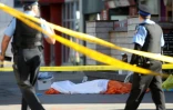 Des policiers à côté du corps d'une des victimes renversées par une camionnette le 23 avril 2018 à Toronto