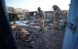Des soldats russe devant le cadavre d'un militaire ukrainien, dans le village de Kazatchïa Loknïa (région de Koursk, Russie) le 19 mars 2025
