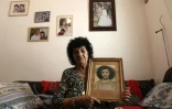 Shoshana Dugma, 83 ans, pose avec un portrait d'elle plus jeune, le 27 juin 2016 à son domicile d'Elyakhin, en Israël
