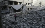 Un garçon marche au milieu des immeubles détruits par les bombardements du régime syrien à Douma dans la Ghouta orientale, le 19 mars 2018