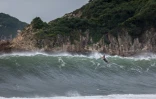 Un surfeur prend une vague dans un océan agité par le typhon Saola qui se dirige vers Hong Kong le 1er septembre 2023.