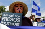 Un manifestant anti-gouvernement brandit une pancarte "Pourquoi sont-ils des prisonniers politiques ?" lors d'une marche réclamant la libération de prisonniers politiques à Managua, le 15 août 2018