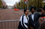 Un couple prend un selfie sur le parcours du cortège du couronnement, le 4 mai 2023 à Londres