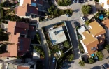 Vue aérienne de la maison du Palestinien Saadat Gharib (C) en Cisjordanie occupée, encerclée par les logements de colons israéliens qui se sont rapprochés de son jardin, lui laissant un bout de jardinet entouré d'un grillage, le 19 juillet 2022 à Beit Ijza, en Cisjordanie occupée