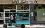 Des Cubains passent devant une pharmacie à La Havane, le 2 juillet 2025