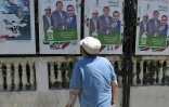 Un homme regarde des affiches électorales à Algers, le 11 juin 2021, à la veille des élections législatives 