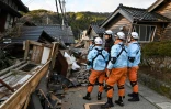 Des pompiers inspectent des maisons en bois effondrées à Wajima, dans la préfecture d'Ishikawa, le 2 janvier 2024, au lendemain d'un important séisme