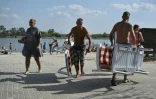 Des personnes se détendent sur les rives du lac Sloviansk, dans la région de Donetsk, le 6 août 2025