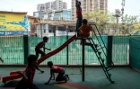 Des élèves jouent dans  "l'école du feu rouge", qui accueille des enfants défavorisés dans des conteneurs aménagés en salles de cours sous un pont autoroutier, le 18 mai 2026 à Bombay
