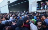 Des Palestiniens déplacés se ruent sur  un entrepôt du Programme alimentaire mondial à Deir el-Balah, dans le centre de la bande de Gaza, le 28 mai 2025