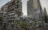 Des secouristes dans les décombres d'un immeuble résidentiel touché par des frappes de drones et de missiles russes sur un immeuble résidentiel à Kiev, le 14 mai 2026 en Ukraine
