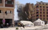 Des Palestiniens se précipitent pour se mettre à l'abri après qu'une frappe israélienne a touché un immeuble à proximité à Jabalia, dans le nord de la bande de Gaza, le 20 août 2025

