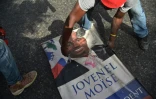 Un manifestant découpe un portrait du président haïtien Jovenel Moise, le 7 juillet 2018 à Port-au-Prince
