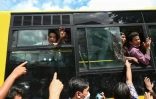 Un bus transportant des détenus libérés de la prison d'Insein à Rangoun passe devant la foule qui attend devant l'établissement, le 19 octobre 2021