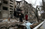 Des résidents passent devant un immeuble d'habitation détruit par une attaque de missiles russes dans la ville de Selydove, dans la région de Donetsk, le 16 février 2024