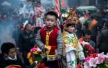 Des enfants, maquillés et habillés de costumes bordés et colorés, en parade, debout sur des palanquins, dans les rues de Tufang, le 11 février 2017 dans l'est de la Chine