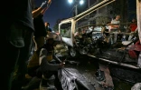 Des passants et des secouristes inspectent la carcasse du minibus dans lequel une bombe a explosé, à Jaramana, près de la capitale syrienne, Damas, le 6 août 2026
