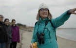Sur cette photo prise et diffusée par l'ONG Save Coastal Wildlife, la directrice de l'organisation Jenna Reynolds signale à son équipe un groupe de phoques nageant dans la baie de Sandy Hook (New Jersey), le 1er janvier 2024