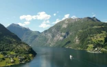 Vue aérienne montrant un ferry naviguant dans le fjord de Geiranger, en Norvège, le 26 juin 2024