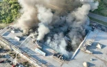 Photo diffusée par l'administration militaire régionale de Dnipropetrovsk, le 21 août 2026, montrant des pompiers luttant contre un incendie sur le site d'un centre commercial endommagé par une frappe russe à Kryvyï Rig, en Ukraine