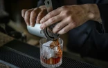 Le barman Shingo Miyachi prépre un cocktail negroni avec un glaçon de l'usine kuramoto Ice au bar de l'hôtel Hilton de Narita, au Japon, le 19 juin 2026