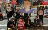 Des proches d'otages israéliens retenus à Gaza brandissent des pancartes appelant à la fin définitive de la guerre et à la libération des otages, lors d'un rassemblement devant le ministère de la Défense à Tel-Aviv, le 8 mars 2025
