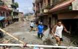 Des habitants passent devant des maisons noyées sous la boue après des crues soudaines à Devighat au Népal, le 27 août 2026