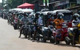 Des motocyclistes font la queue pour effectuer un plein d'essence, le 12 avril 2022 dans la capitale Colombo