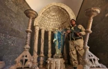 Un soldat des "Brigades de Babylone" près d'une statue de la vierge Marie décapitée par les jihadistes de l'EI, le 22 novembre 2016 à Khidr Ilyas, en Irak