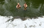 Erina Hey et Franz Mayr se baignent dans les eaux glaciales de la rivière Eisbach dans l'English Garden park de Munich, le 16 janvier 2021