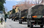 Des camions de l'armée italienne transportent des cercueils à travers la ville de Bergame, depuis le cimetière de la ville jusqu'à des crematoriums d'autres villes italiennes, le 26 mars 2020