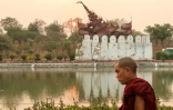 Un moine bouddhiste passe devant le palais de Mandalay endommagé par un séisme, le 31 mars 2025 à Mandalay (Birmanie)