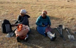 Deux femmes marquent une pause après avoir passé la nuit à la recherche de ce qu'elles pensent être des diamants, dans le sol du village sud-africain de KwaHlathi le 15 juin 2021