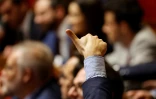 Un député français lève le pouce indiquant le vote de son groupe pour un vote public lors d'une session de débat sur le projet de budget 2025, à Paris, le 22 octobre 2024