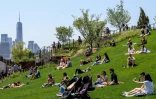 Des personnes prennent le soleil sur les pelouses du parc aérien "Little Island" sur le fleuve Hudson, le 21 mai 2021 à New York