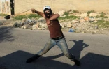 Un militant palestinien s'en prend aux forces de sécurité israéliennes, le 11 décembre 2015 dans le village de Kafr Qaddum, près de Naplouse, en Cisjordanie occupée