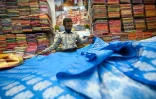 Un vendeur montre des saris traditionnels dans une boutique de Varanasi, le 20 novembre 2021 en Inde
