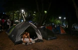 Une femme est assise sur une tente dans un campement de fortune après un séisme de magnitude 7,4 à Cali, en Colombie, le 15 août 2026