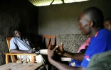 Un agent médical Ken Olela (d) s'entretient avec Lawrence Owino pour le convaincre lui et sa famille de passer des tests de depistage du sida, à Ndiwa dans le comté de Homa Bay (ouest du Kenya), le 10 novembre 2015