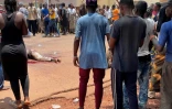 Un homme soupçonné d'avoir participé à une attaque "terroriste" déjouée gît sur le sol après avoir été battu par la foule, devant la base militaire de Kati, au Mali, le 22 juillet 2022