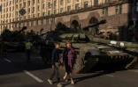 Des habitants se promènent sur l'avenue Khrechtchatyk, l'artère principale de Kiev, où des épaves de blindés russes sont exposées à l'occasion de la fête de l'Indépendance de l'Ukraine, le 24 août 2023