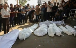Des Palestiniens prient près des corps de membres de la famille Al-Chaer, dont une femme enceinte, tués selon la Défense civile dans une frappe israélienne sur leur maison à Gaza-ville, lors de leurs funérailles à l'hôpital Al-Chifa, le 23 juillet 2025
