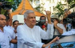 Le président sortant Ranil Wickremesinghe (c) montre son doigt teinté d'encre après avoir voté à l'élection présidentielle, le 21 septembre 202 à Colombo