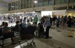 Des passagers attendent devant l'aéroport Napoléon Bonaparte d'Ajaccio, en Corse, le 3 octobre 2024