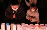 Des enfants prient lors d'une cérémonie matinale à la mémoire des victimes à l'occasion du 30e anniversaire du tremblement de terre de Kobe, le 17 janvier 2025 au Japon