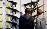 Deux hommes regardent des fusils semi-automatiques lors d'une foire aux armes, le 29 mars 2019 à Lucerne, en Suisse