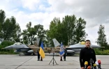 Le président ukrainien Volodymyr Zelensky devant deux chasseurs F-16 lors d'une cérémonie dans un lieu tenu secret en Ukraine, le 4 août 2024