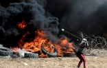 Un manifestant palestinien utilise un lance-pierre lors d'affrontements avec les forces israéliennes à l'est de Gaza, à la frontière avec Israël le 27 avril 2018
