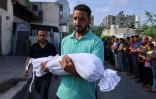 Un Palestinien porte le corps d'un enfant tué par une frappe israélienne, pendant des funérailles à Khan Yunis, dans le sud de la bande de Gaza, le 10 octobre 2023